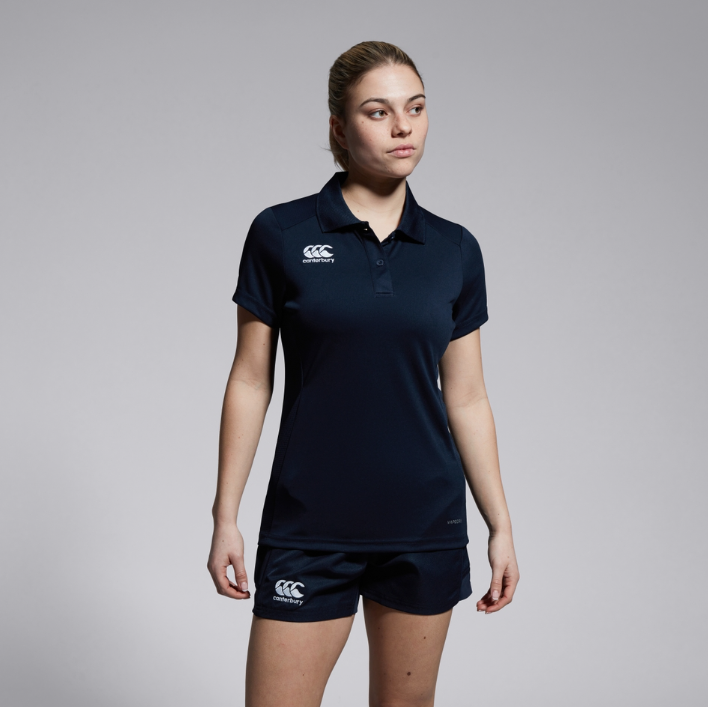 Person wearing a navy polo shirt and shorts with a visible brand logo on a