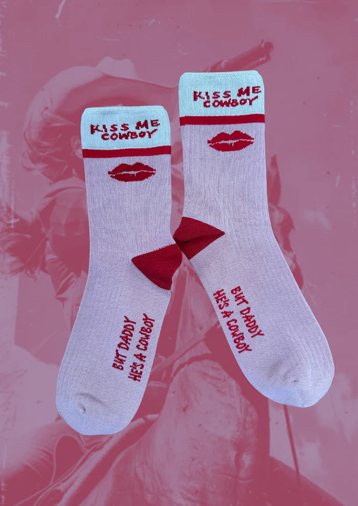 White socks with red text and lipstick prints on a pink background